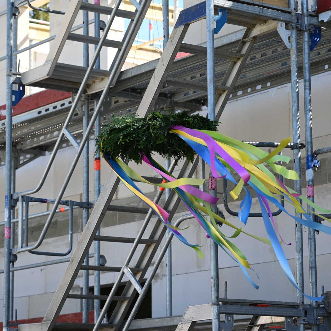Richtkranz mit buntem Schmuck am Gerüst des Neubaus — Richtfest Krankenstation Tierheim Hannover April 2026